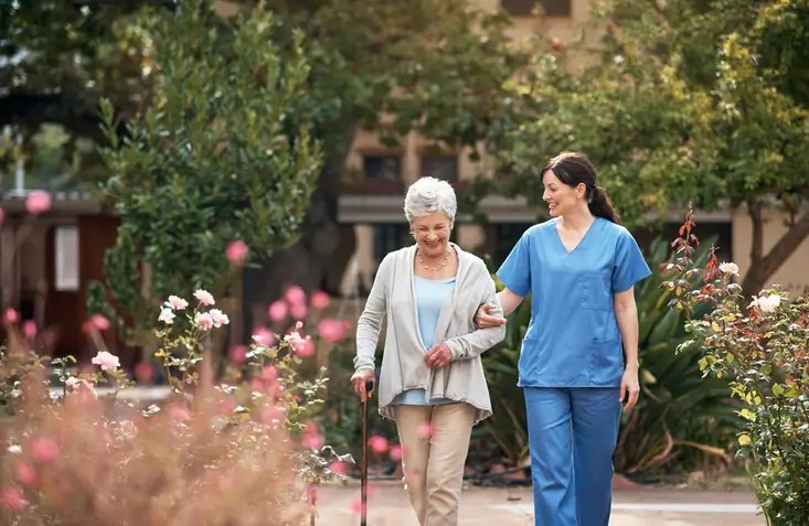 A caregiver and her patient out for a walk in the garden at The Guest House Skilled Nursing and Rehabilitation in Shreveport