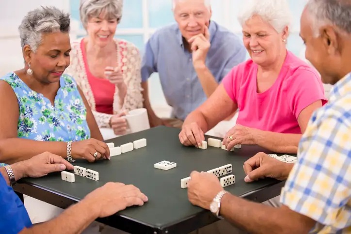 Senior friends playing dominoes at The Guest House Nursing Home in Shreveport