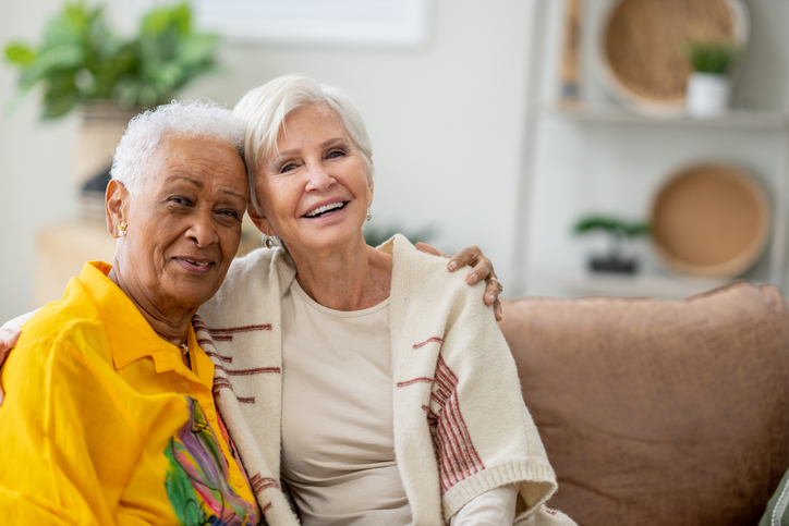 Two senior friends sit together in their long-term care residence in Shreveport, LA