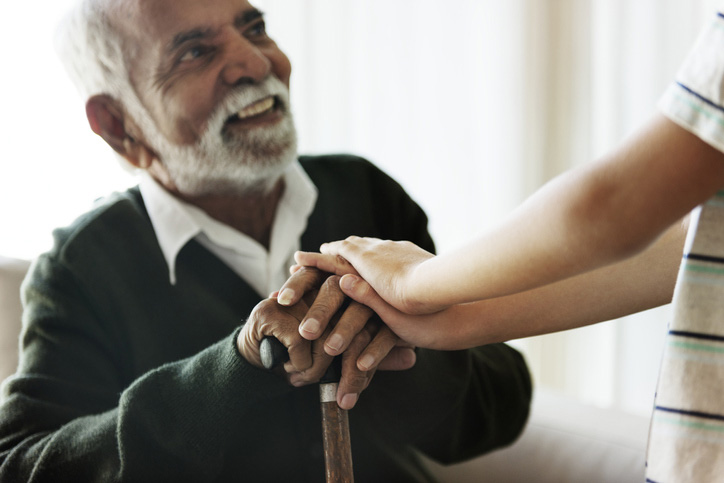 A senior man in memory care smiling at his grandchild in Shreveport, LA
