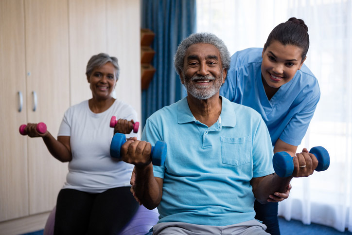 Two seniors lifting weights during outpatient therapy session in Shreveport, LA