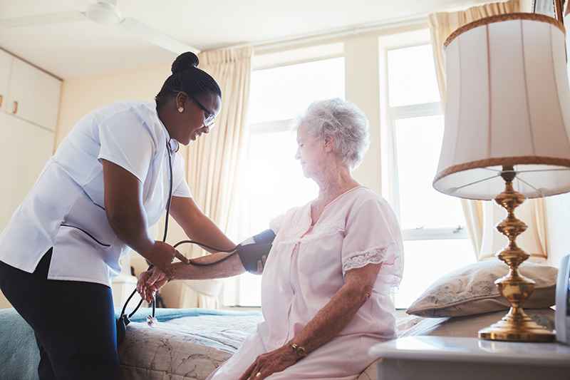 A nurse at the guest house, checks an elderly woman's blood pressure in Shreveport, LA