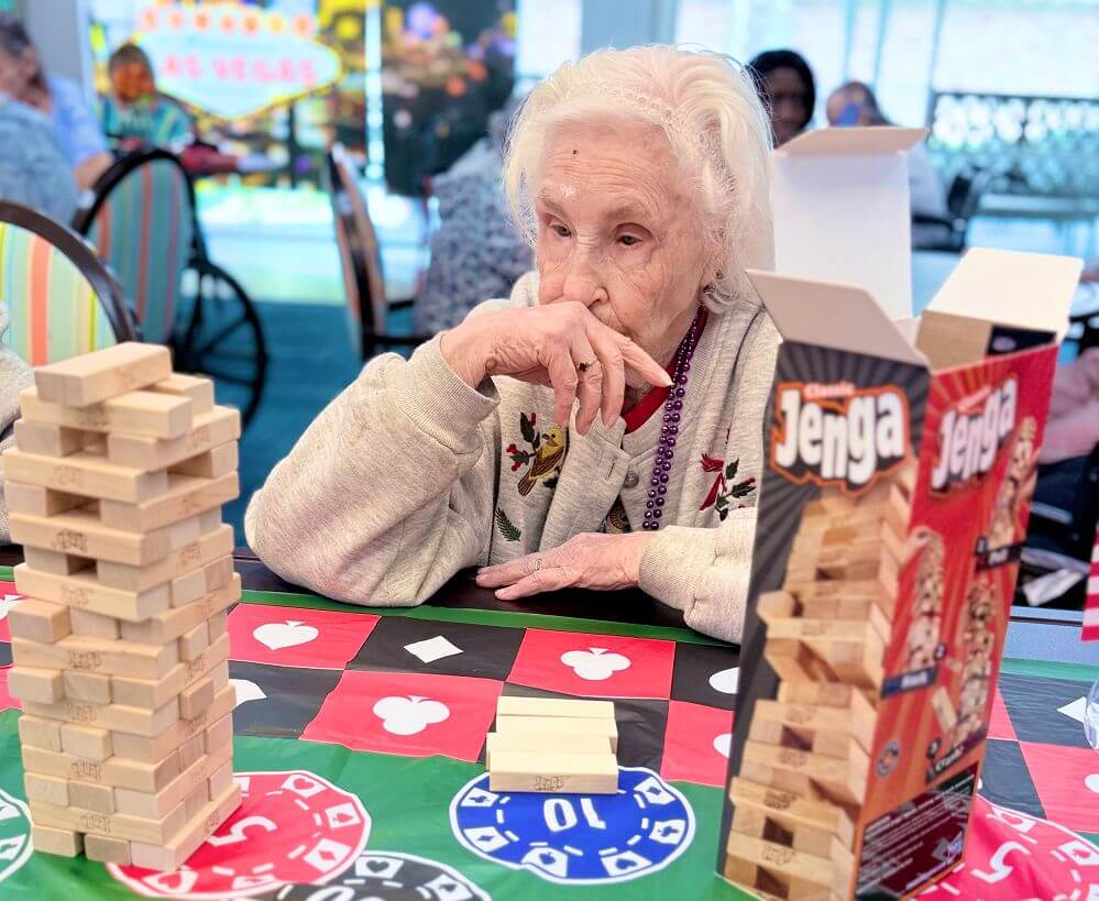 An elderly lady enjoys a game of Jenga in a nursing facility located in Shreveport, LA.