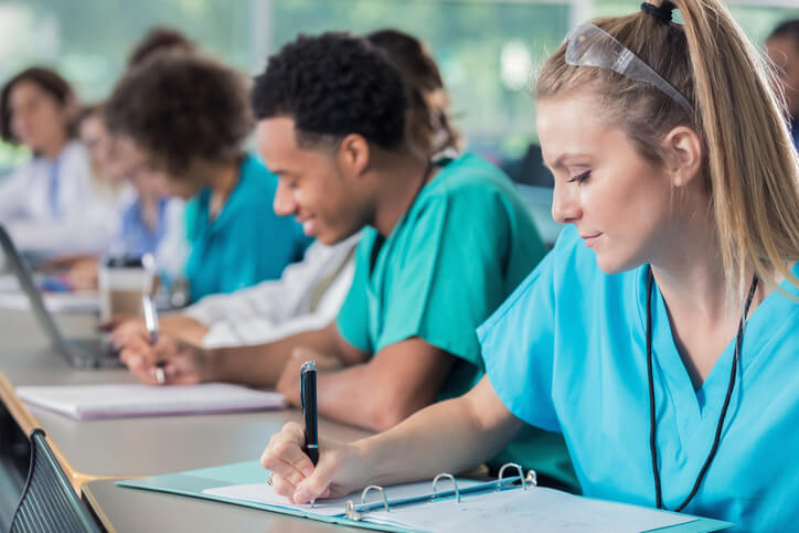Nurses seated at a table writing about the tuition reimbursement program in Shreveport, LA