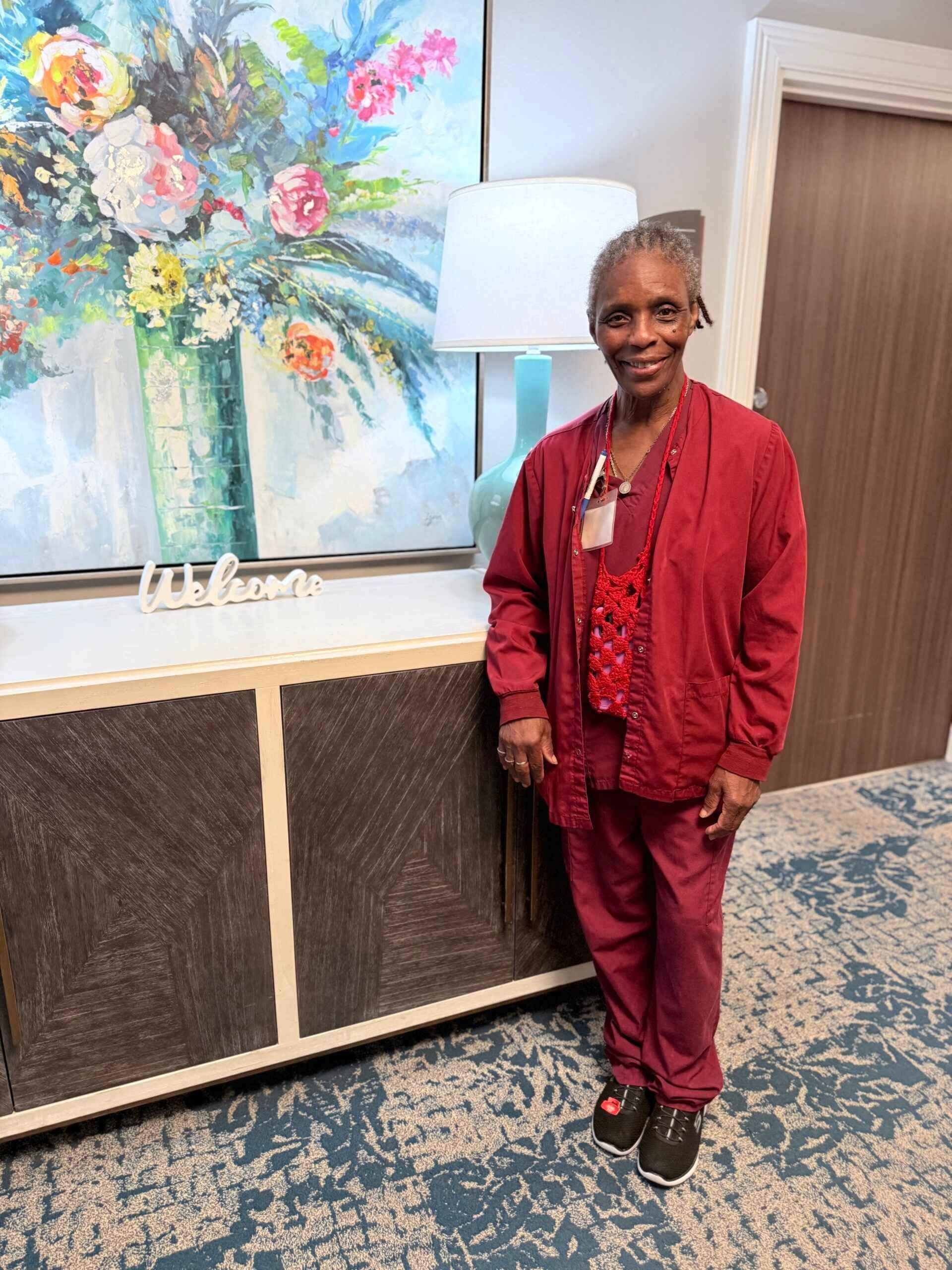 Woman in red stands by a cabinet, representing trusted nursing care in Shreveport, LA