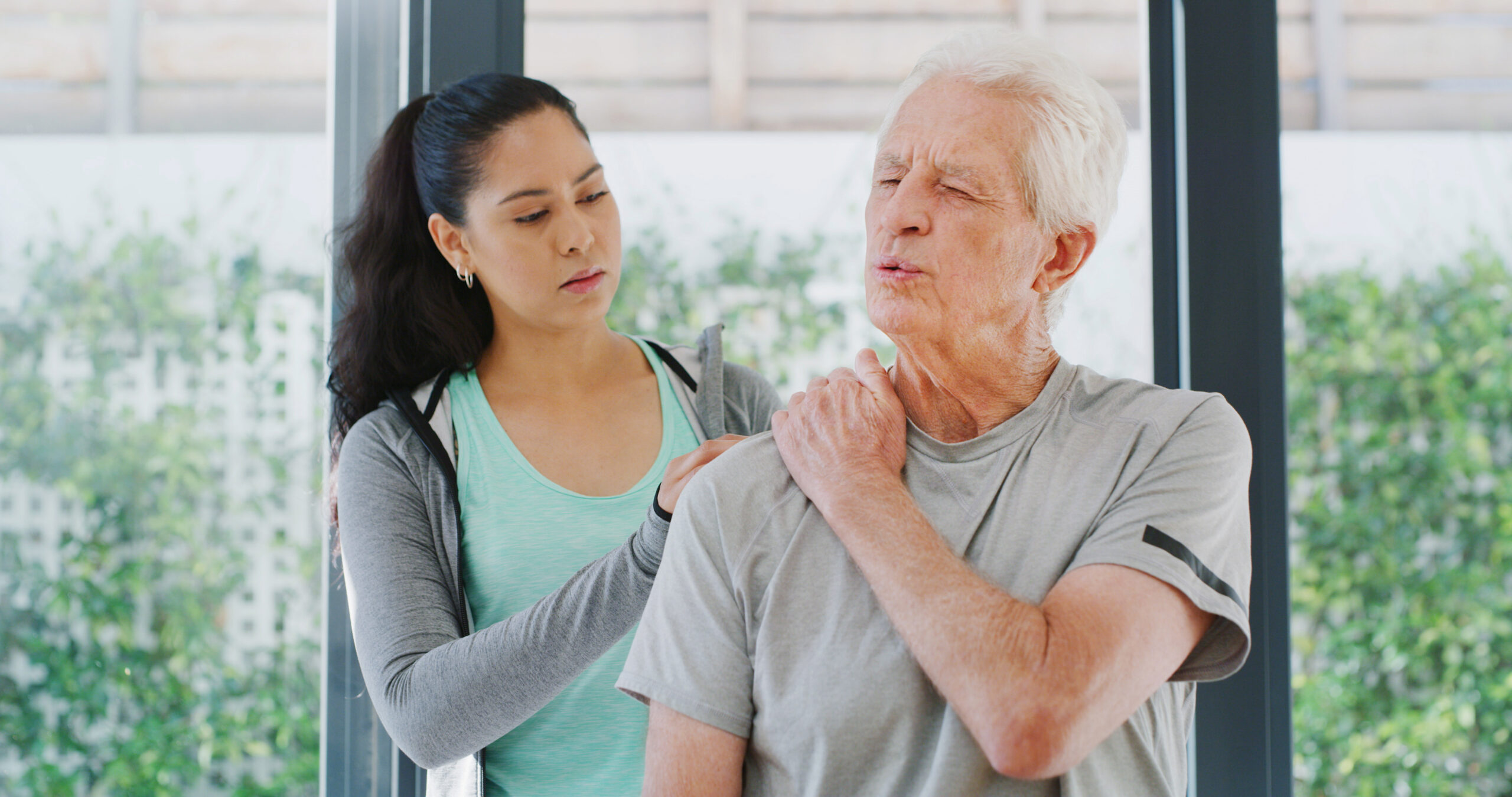 Physiotherapy, shoulder pain and advice with old man in clinic for muscle healing, rehabilitation and injury. Physical therapy, osteoarthritis and recovery with senior patient and woman in office