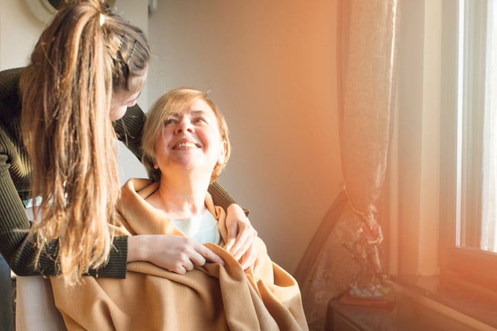 Caregiver comforts elderly woman with dementia
